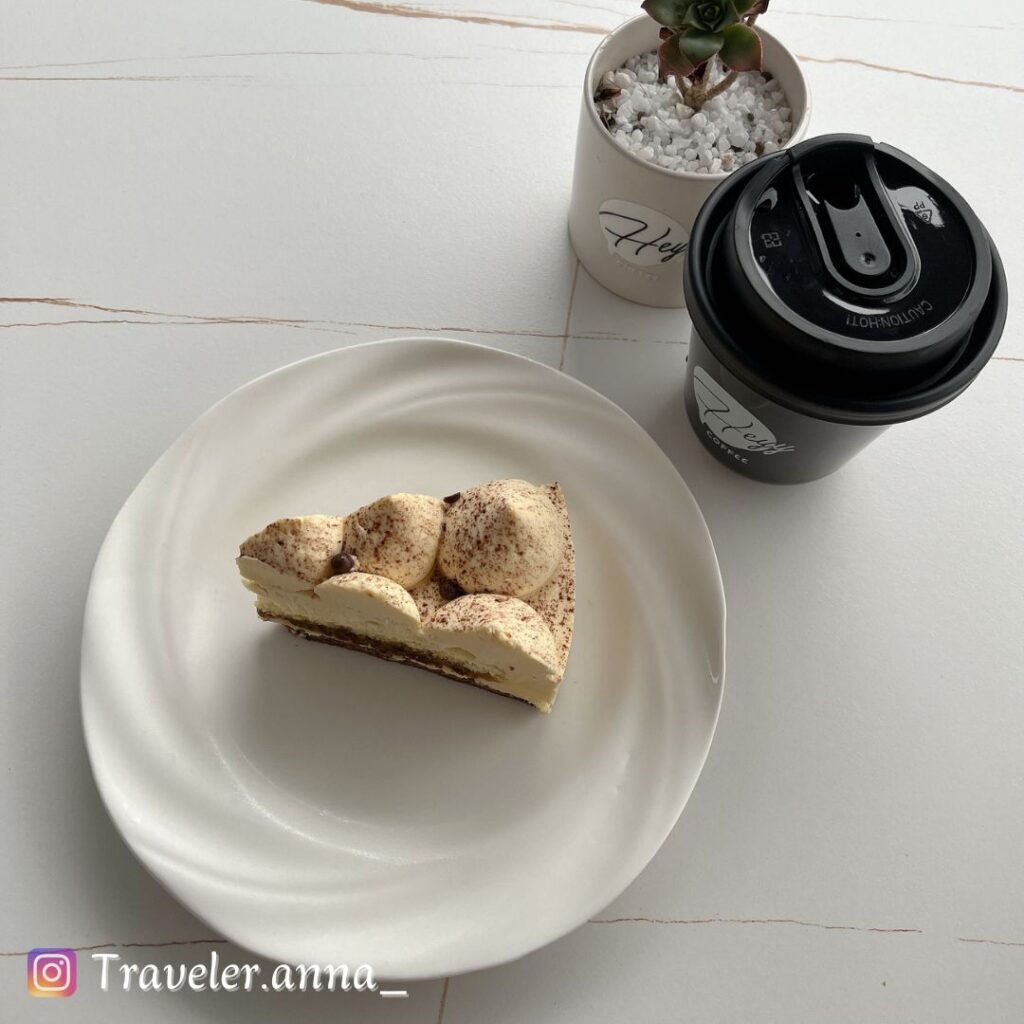 a piece of cake on a plate next to a cup of coffee,heyy-coffee-traveleranna